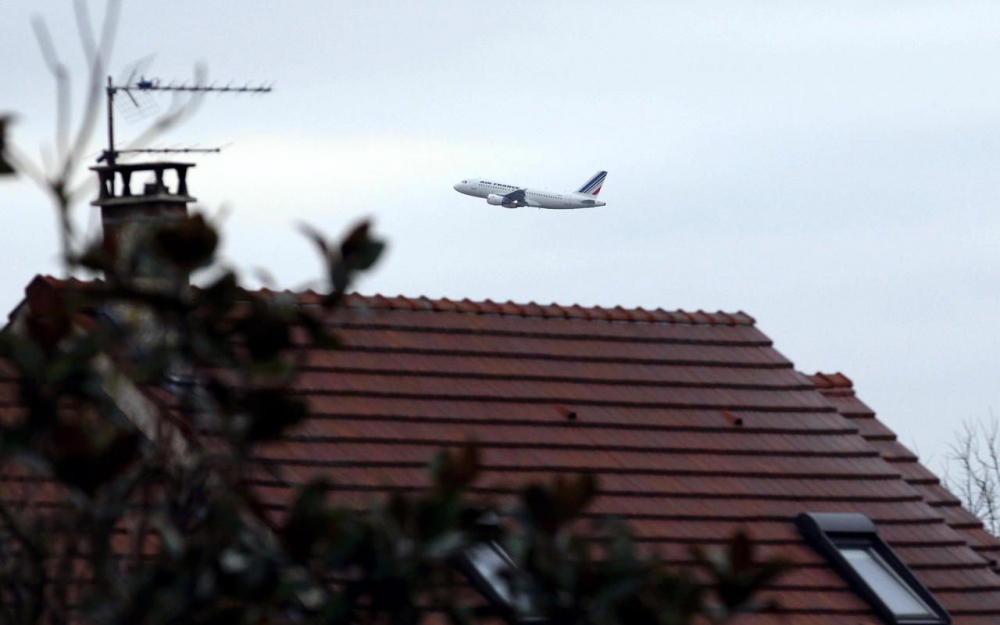avion très bas audessus d'un toit d'habitation